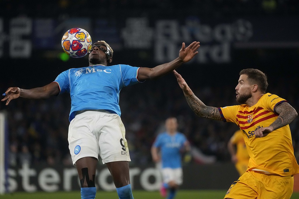 Victor Osimhen (L) of Napoli and Inigo Martinez of Barcelona challenge for the ball during their UEFA Champions League round of 16 first-leg match in Naples, Italy, February 21, 2024. /CFP