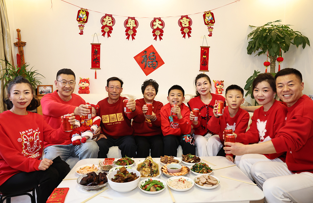 A family poses for a photo in front of the camera before having a reunion dinner in Lanzhou, northwest China's Gansu Province, February 9, 2024. /CFP