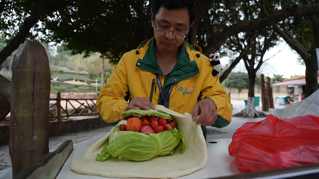 A keeper at the Loca Joy Animal Theme Park in Yongchuan, Chongqing prepares a special meal for the animals on February 21, 2024. /CFP