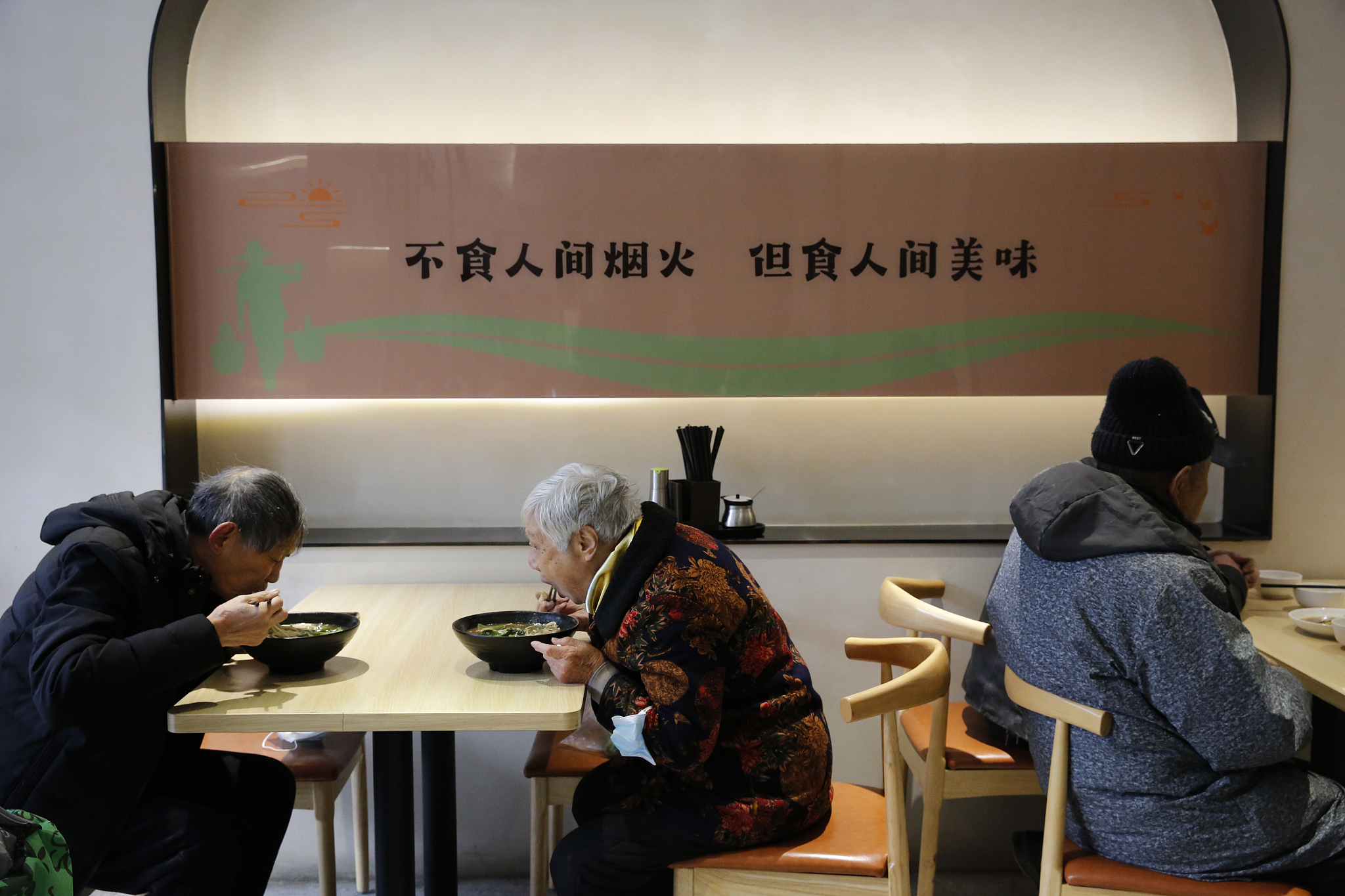 Elderly residents eat at a community dining hall. /CFP