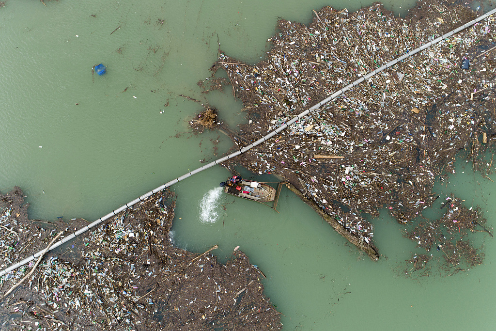 Utility company workers push the waste to the shore of Lim River near Priboj, Serbia, January. 30, 2023. /CFP