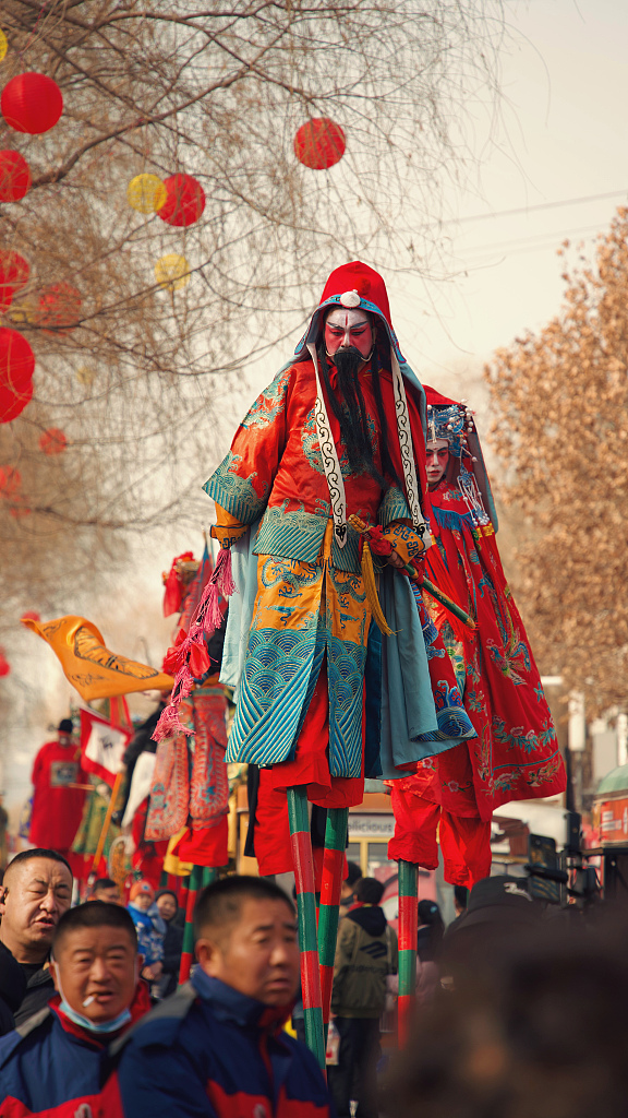A stilt walker brings viewers an eye-catching performance as a part of the Shehuo parade held on a street in Lanzhou, Gansu Province, on February 16, 2024. It is a time-honored tradition to celebrate Chinese New Year. /CFP  