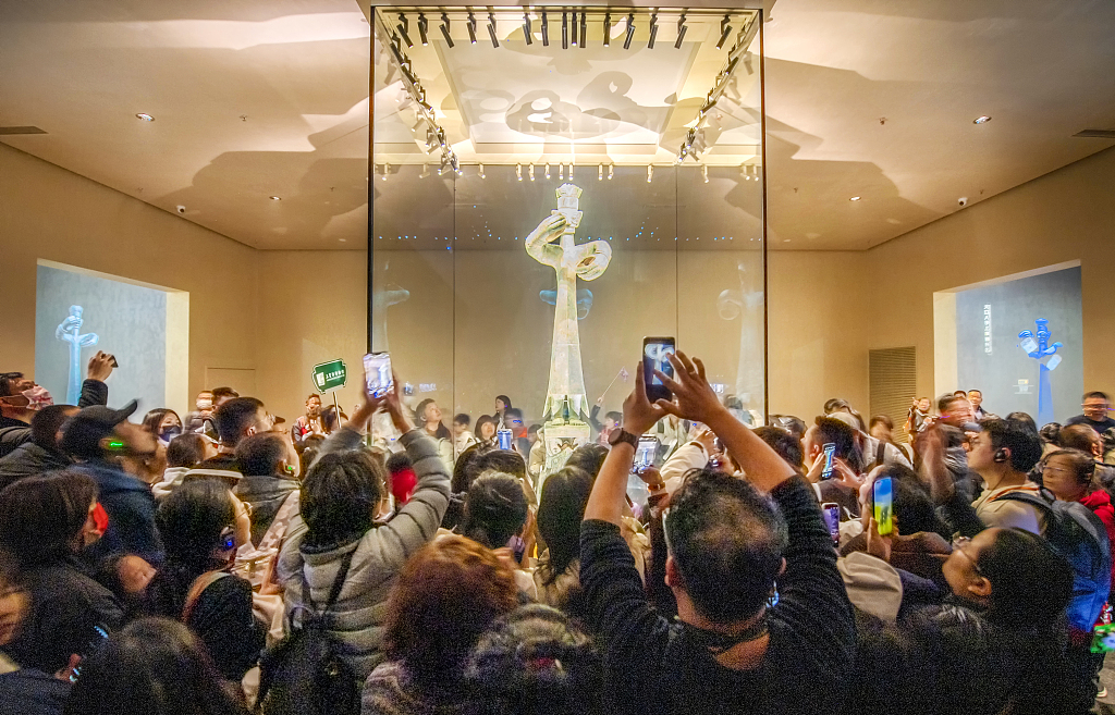 A photo taken on February 12, 2024 shows people taking pictures of a bronze standing figure on display at the Sanxingdui Museum in Guanghan, Sichuan Province. /CFP