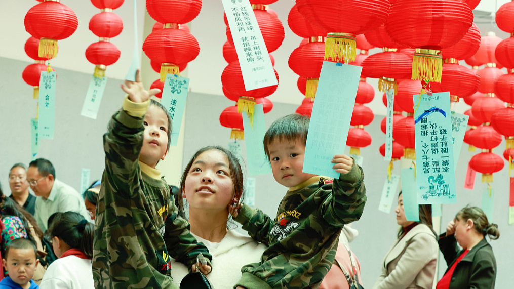 Young visitors try to guess lantern riddles at a square in Qujing City, southwest China's Yunnan Province, February 24, 2024. /CFP