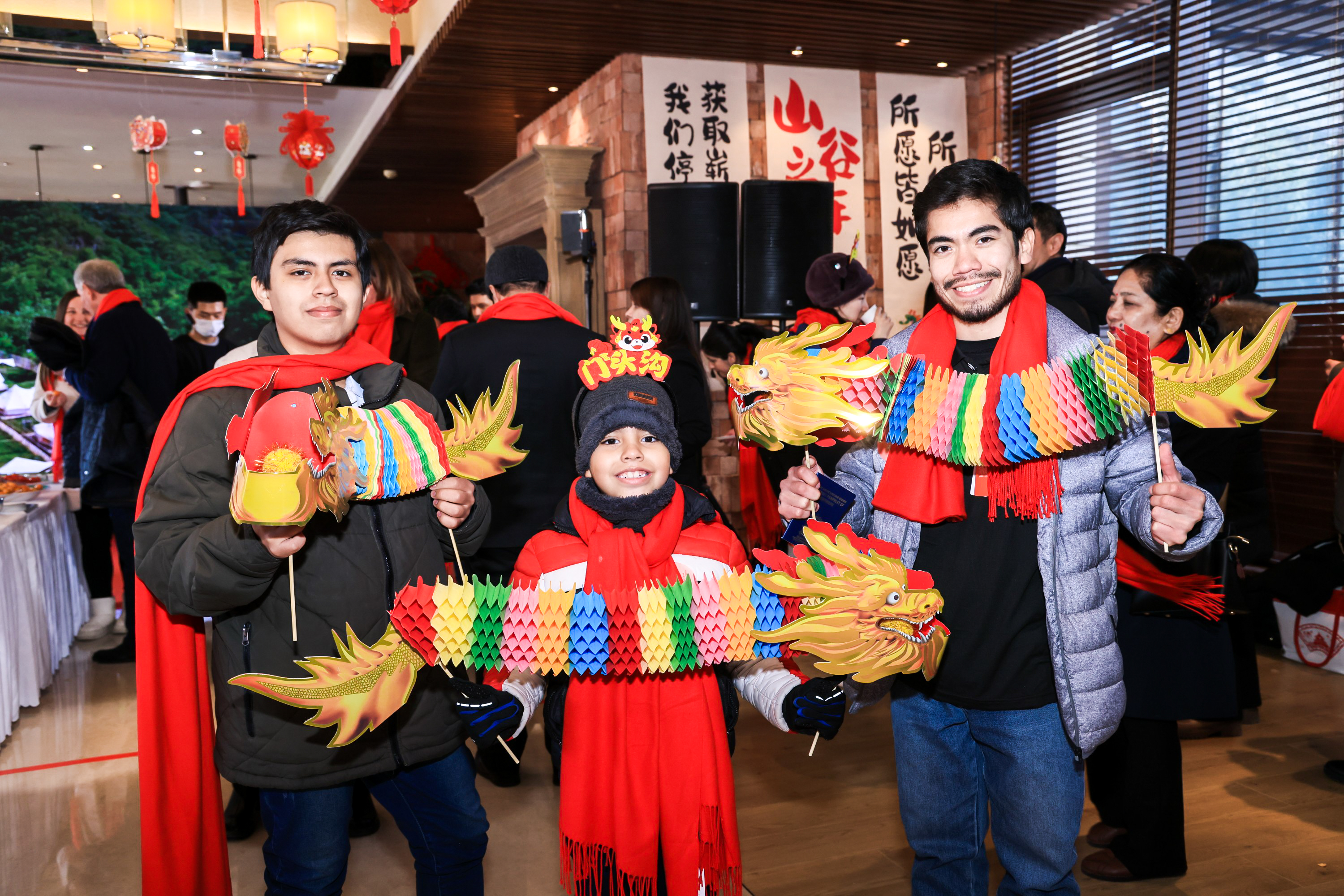 Diplomats and their families hold up accordion paper dragons at a Lantern Festival cultural fair in Beijing on February 23, 2024. /Photo provided to CGTN