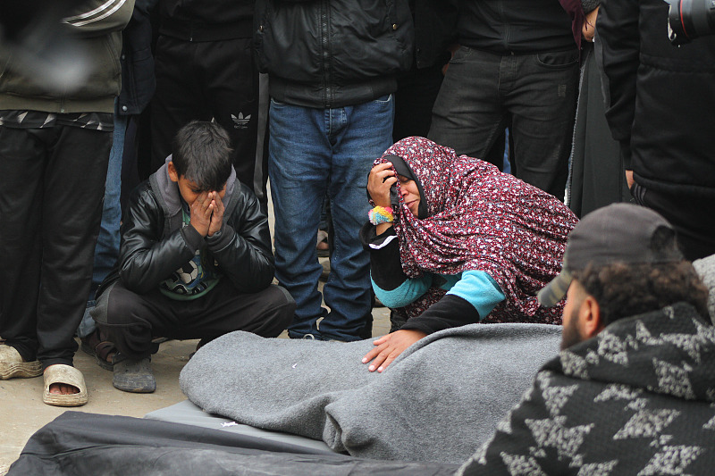 Relatives mourn beside the covered bodies of people killed during Israeli bombardment, outside a hospital in Deir al-Balah, Gaza, February. 23, 2024. /CFP