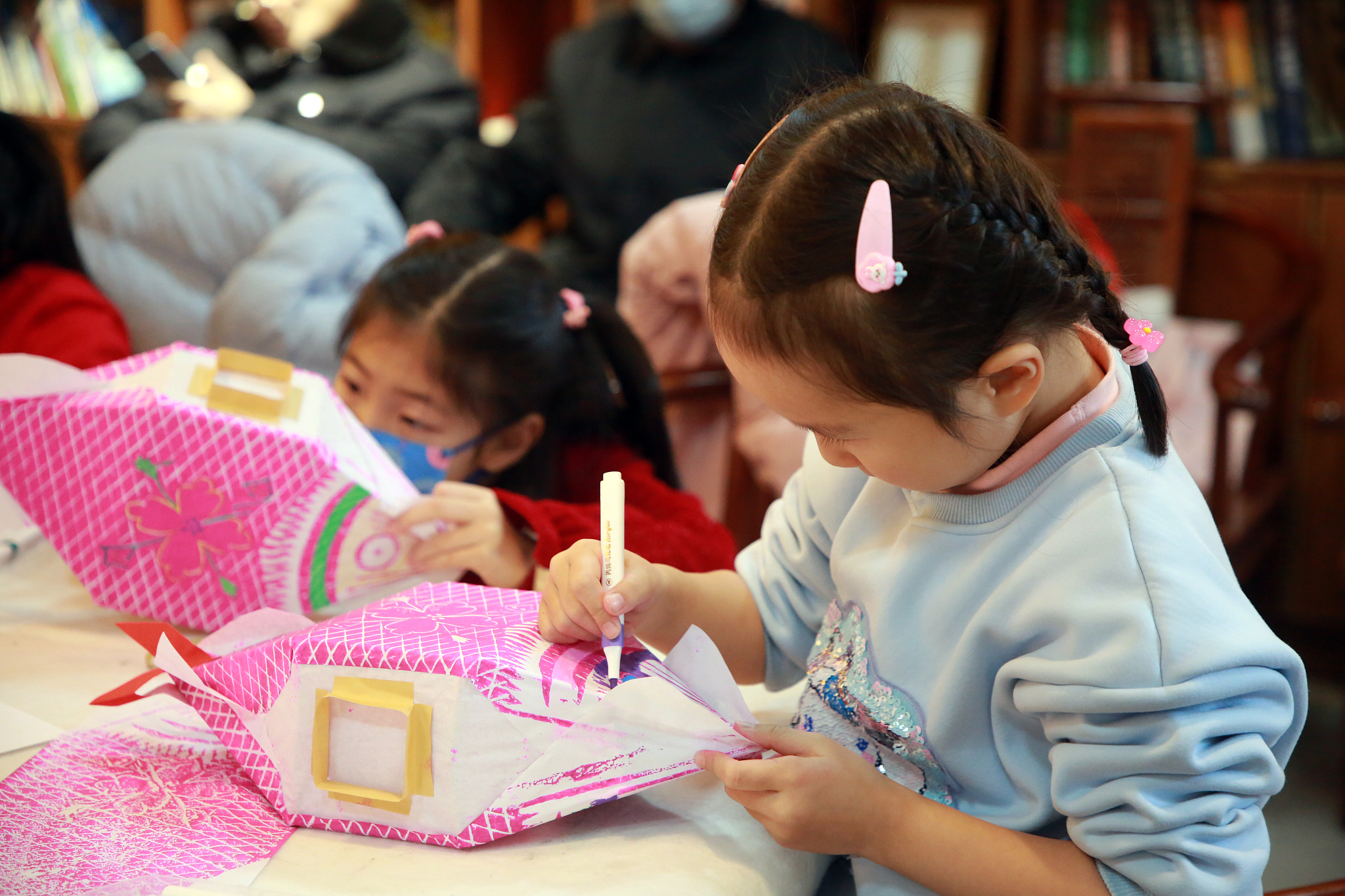 Under the guidance of inheritors of intangible cultural heritage, children discover the joy of creating traditional handmade fish lanterns to celebrate the Lantern Festival, Rizhao City, east China's Shandong Province, February 23, 2024. /CFP