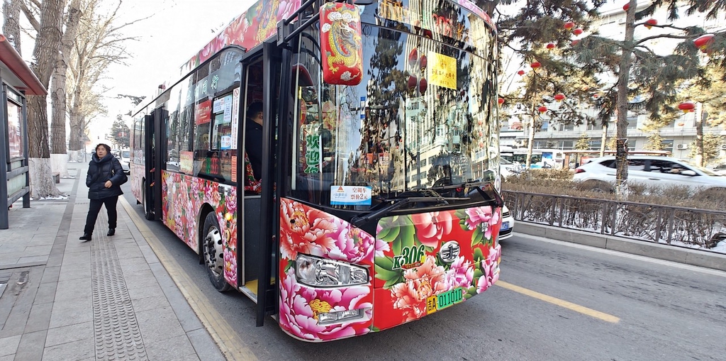 A photo shows a bus covered with a popular flower pattern at a stop in Changchun, Jilin Province, February 20, 2024. /IC