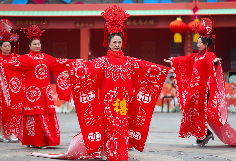 Models show off red qipao featuring creative paper-cut patterns in Qingdao City, Shandong Province, February 24, 2024. /CFP