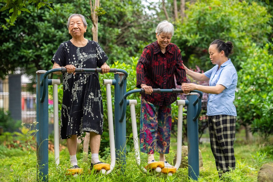 Senior residents exercise with the help of a staff member at a social welfare center in Hanshou County of Changde City, central China's Hunan Province, June 20, 2023. /Xinhua