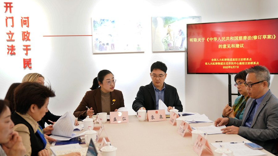 Sheng Hong (4th R), an NPC deputy and Party chief of a residential community in the Hongqiao subdistrict, listens to comments and suggestions of a draft revision to the Charity Law at a civic center in east China's Shanghai, February 7, 2023. /Xinhua