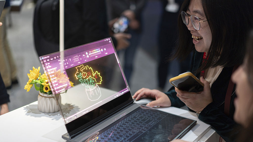 Visitors test the Lenovo Thinkbook transparent display laptop concept during the Mobile World Congress in Barcelona, Spain, February 28, 2024. /CFP