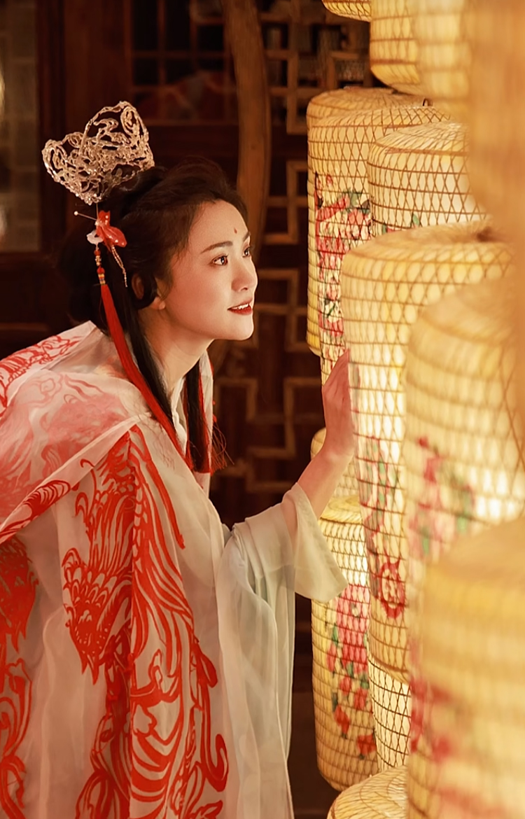 Chen Lingling wears the cloak featuring the paper-cut patterns she made for the Spring Festival. /Screenshot from Xiaohongshu