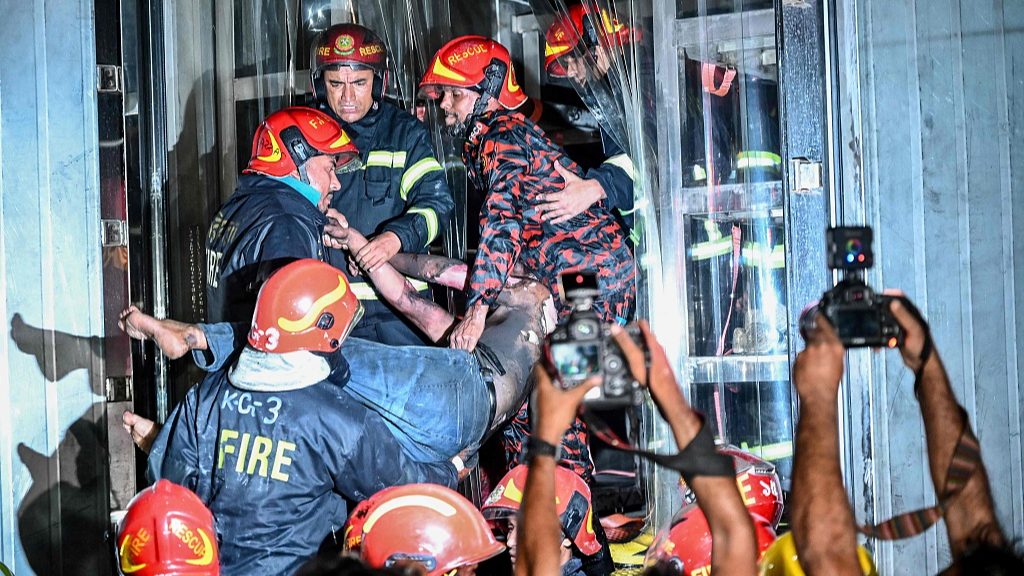 Firefighters carry an injured person during rescue operations in Dhaka, Bangladesh, February 29, 2024. /CFP