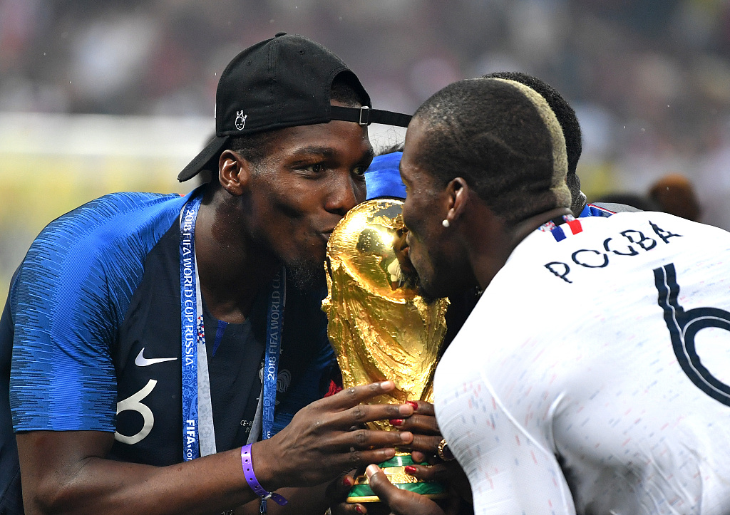 Mathias Pogba (L) and his brothers kiss the trophy after France beat Croatia in the World Cup final at the Luzhniki Stadium in Moscow, Russia, July 15, 2018. /CFP