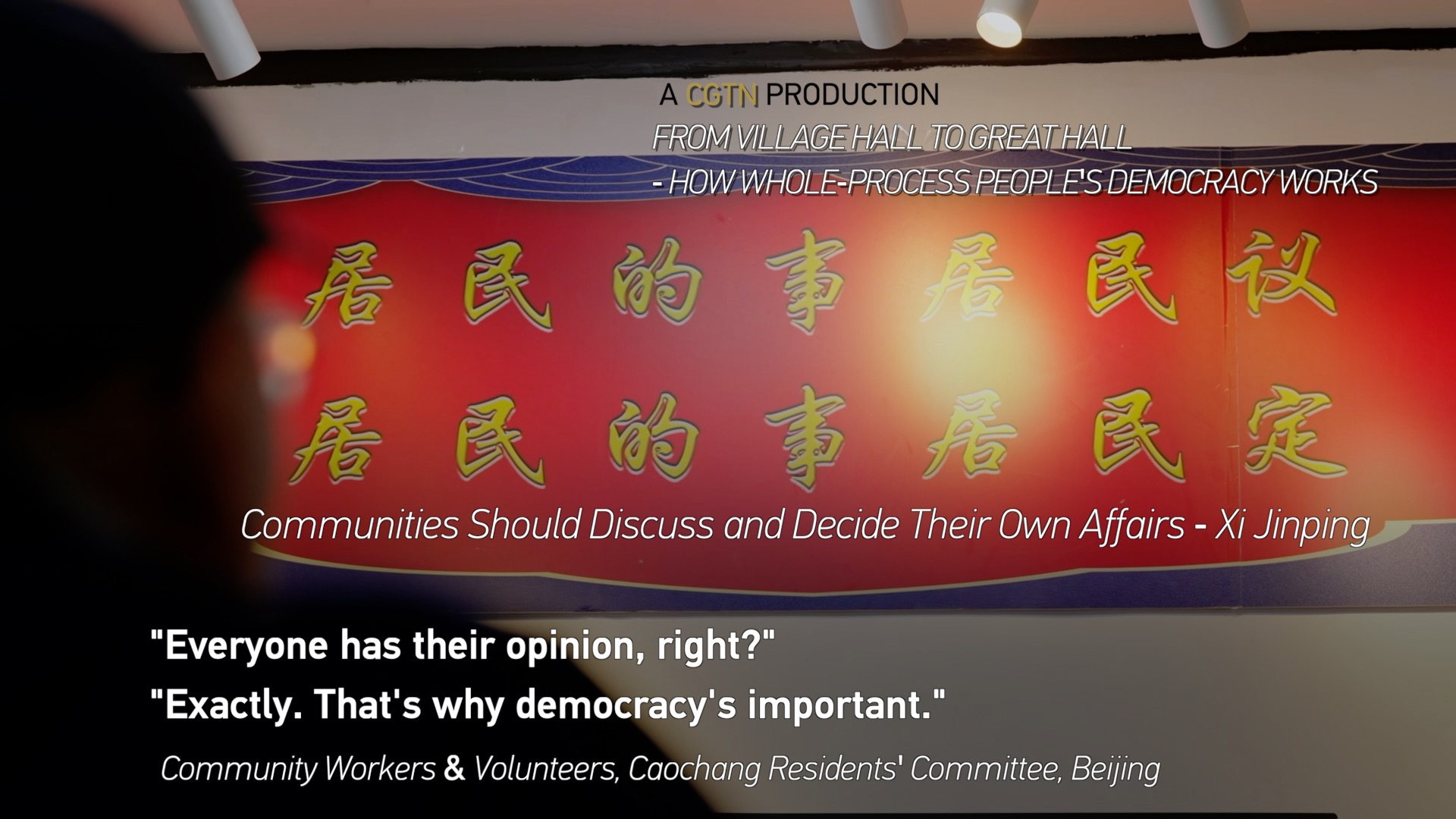 A banner says communities should discuss and decide their own affairs. /CGTN