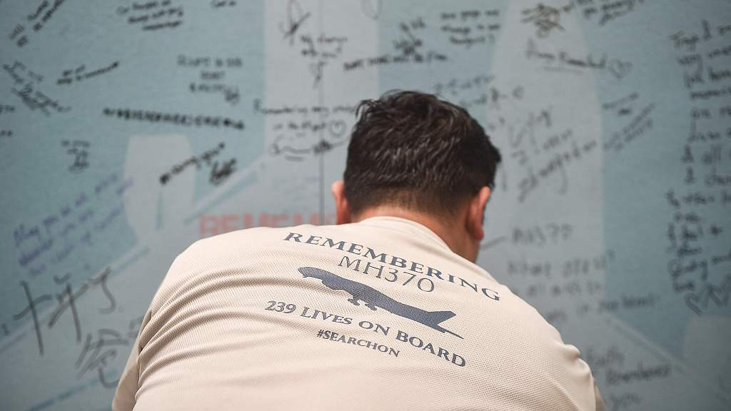 A man writes a message during an event held by relatives of the passengers and supporters to mark the 10th anniversary of the disappearance of the Malaysia Airlines flight MH370 in Subang Jaya, Malaysia, March 3, 2024. /CFP

