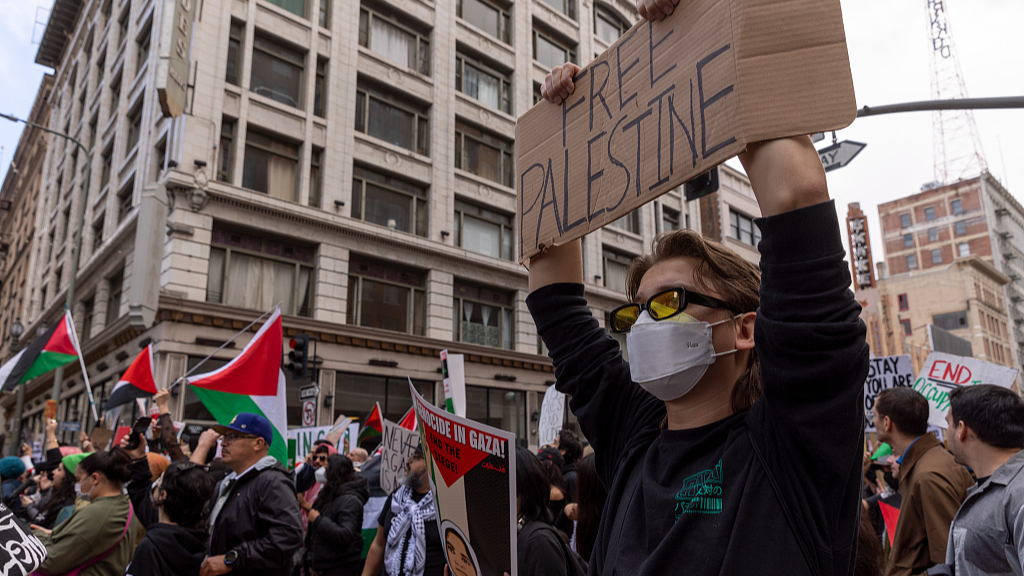 A woman holds a banner as people gather to stage a Pro-Palestinian demonstration in front of the City Hall in Los Angeles, California, U.S., March 2, 2024. /CFP
