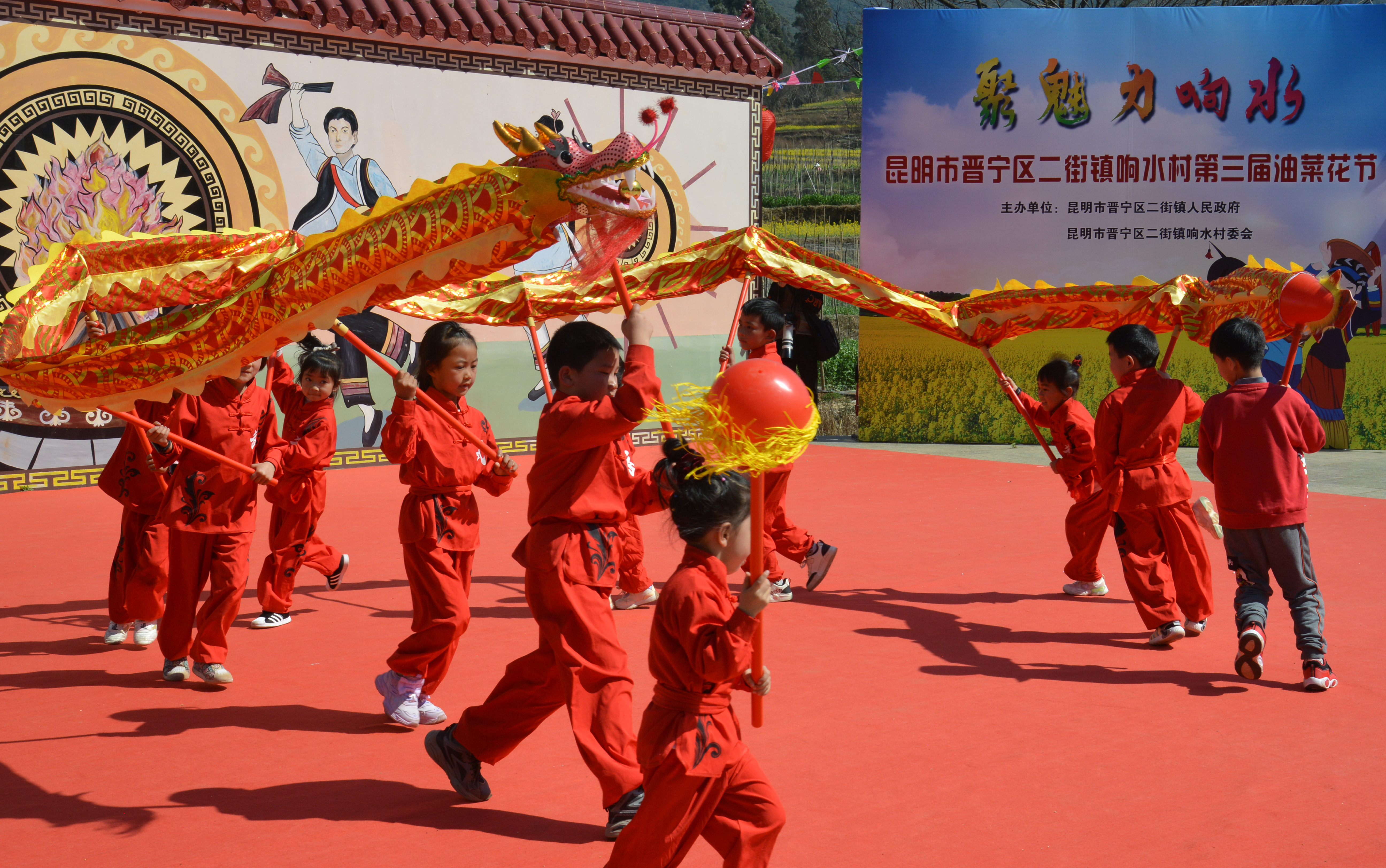 Children perform a dragon dance at the third Rapeseed Flower Festival in Xiangshui Village, in the Jinning District of Kunming, southwest China's Yunnan Province on March 2, 2024. /IC 