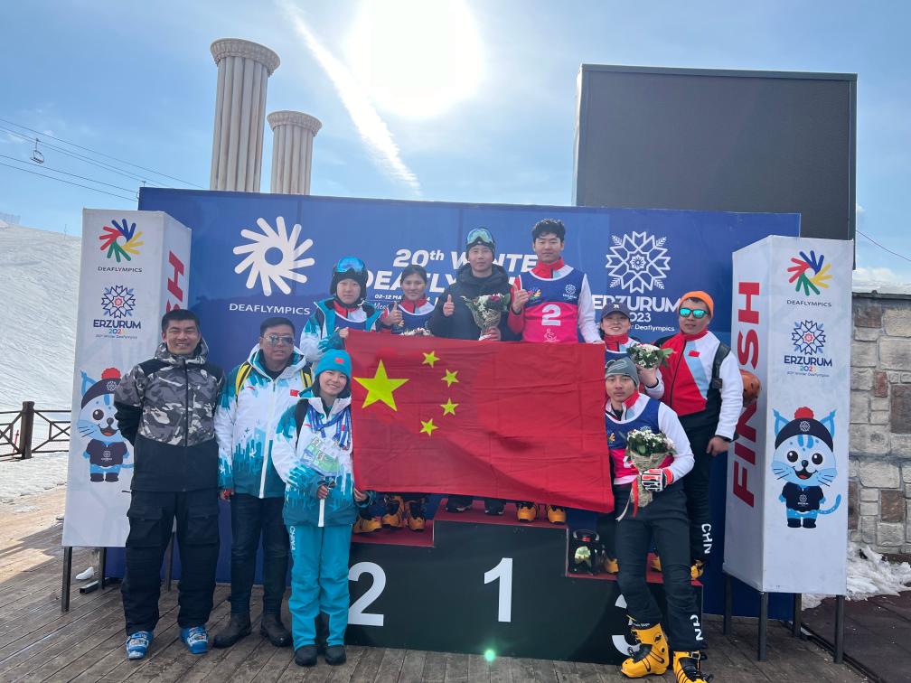 Chinese athletes pose for a family photo after winning the snowboard men's and women's parallel giant slalom gold, silver and bronze medals at the Winter Deaflympics in Erzurum, Türkiye, March 4, 2024. /Xinhua