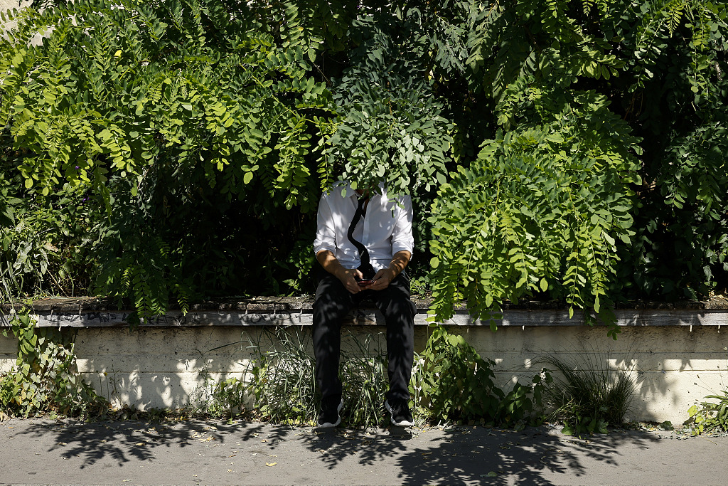 A man sits in the shadow on the Seine river banks in Paris where temperatures rose up to 33 degrees Celsius, France, September 7, 2023. /CFP