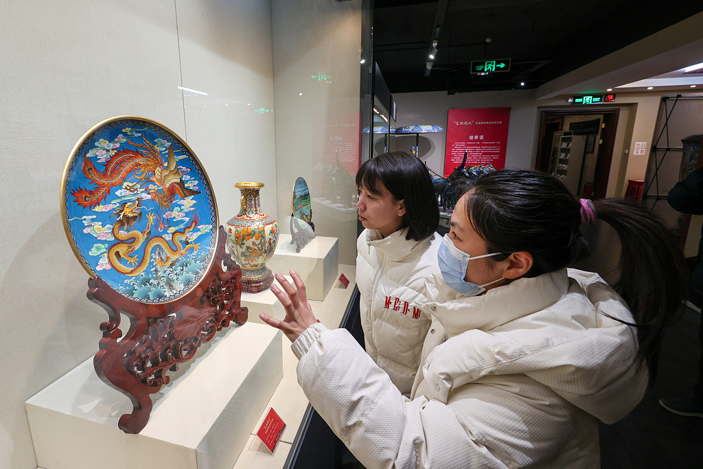Viewers appreciate a cloisonne artwork at an exhibition in the Beijing Enamel Factory. /CFP