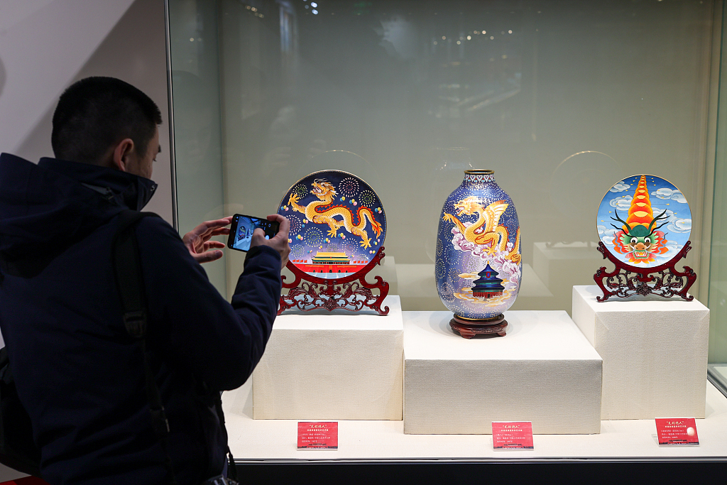 Viewers take photos of the cloisonne artworks at an exhibition in the Beijing Enamel Factory. /CFP