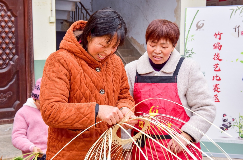 A woman weaves bamboo while another artisan observes in Nanchong, Sichuan Province, March 5, 2024. /IC