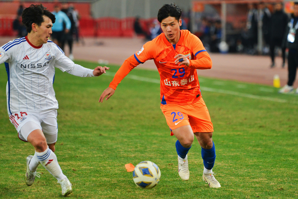 Chen Pu (R) of Shandong Taishan and a player of Yokohama F. Marinos battle for the ball during their AFC Champions League quarterfinal in Jinan, east China's Shandong Province, March 6, 2024. /CFP