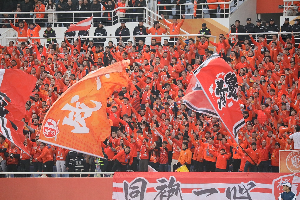 Fans of Shandong Taishan cheer for the team during the match at the Jinan Olympic Sports Center Stadium in Jinan, east China's Shandong Province, March 6, 2024. /CFP