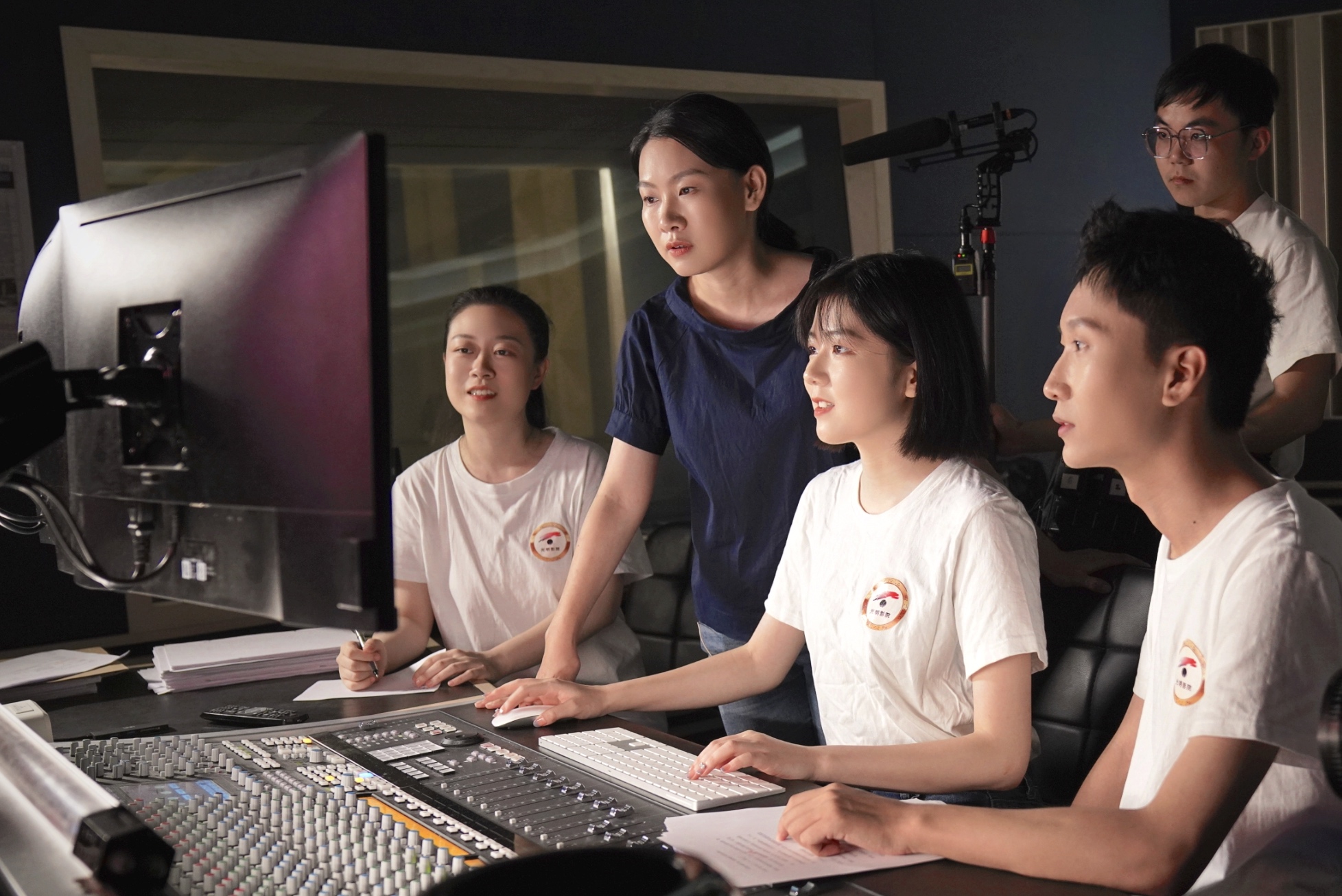 Teachers and students from the Communication University of China edit narrations for the audio-described movies. /Photo provided to CGTN