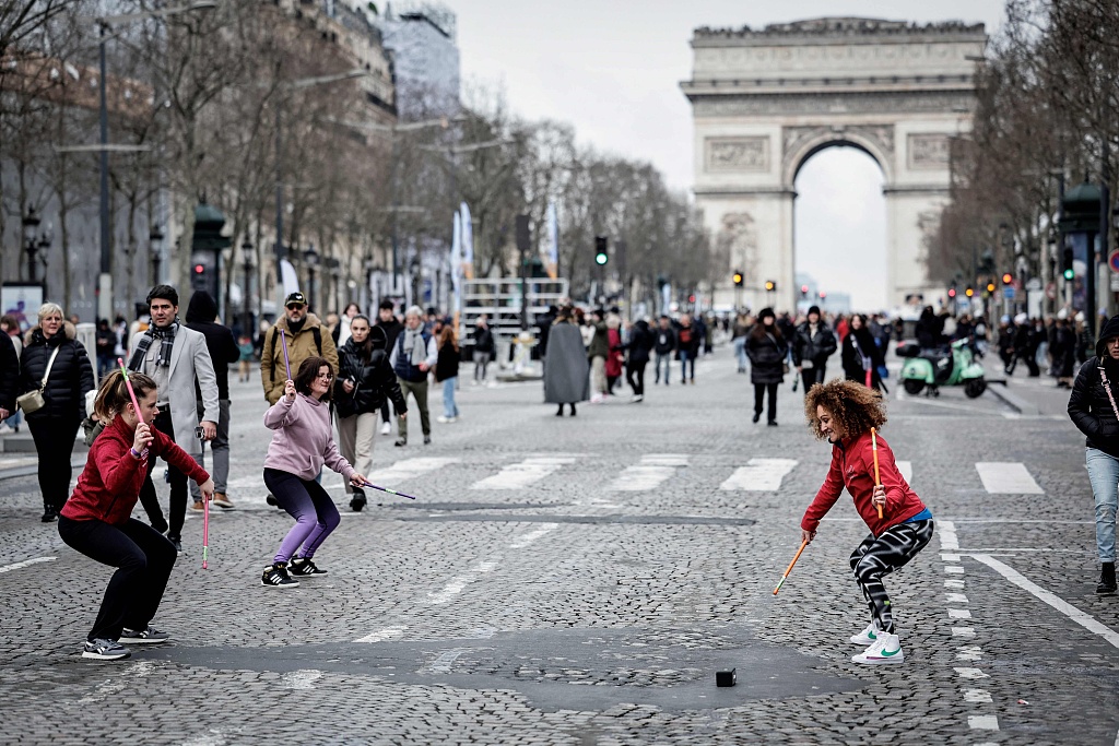 Participants attend a free sport session as part of the 'Le 3 Mars, les sportives gagnent du terrain' ('On March 3, sportswomen gain ground') event, with the Arc de Triomphe in the background on the Champs Elysees avenue in Paris, France, March 3, 2024. /CFP