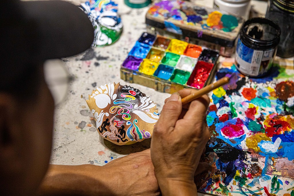 The file photo shows crab shell painter Chen Xianglai working on a piece. /CFP