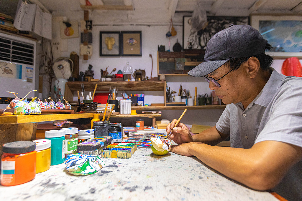 The file photo shows crab shell painter Chen Xianglai working on a piece. /CFP