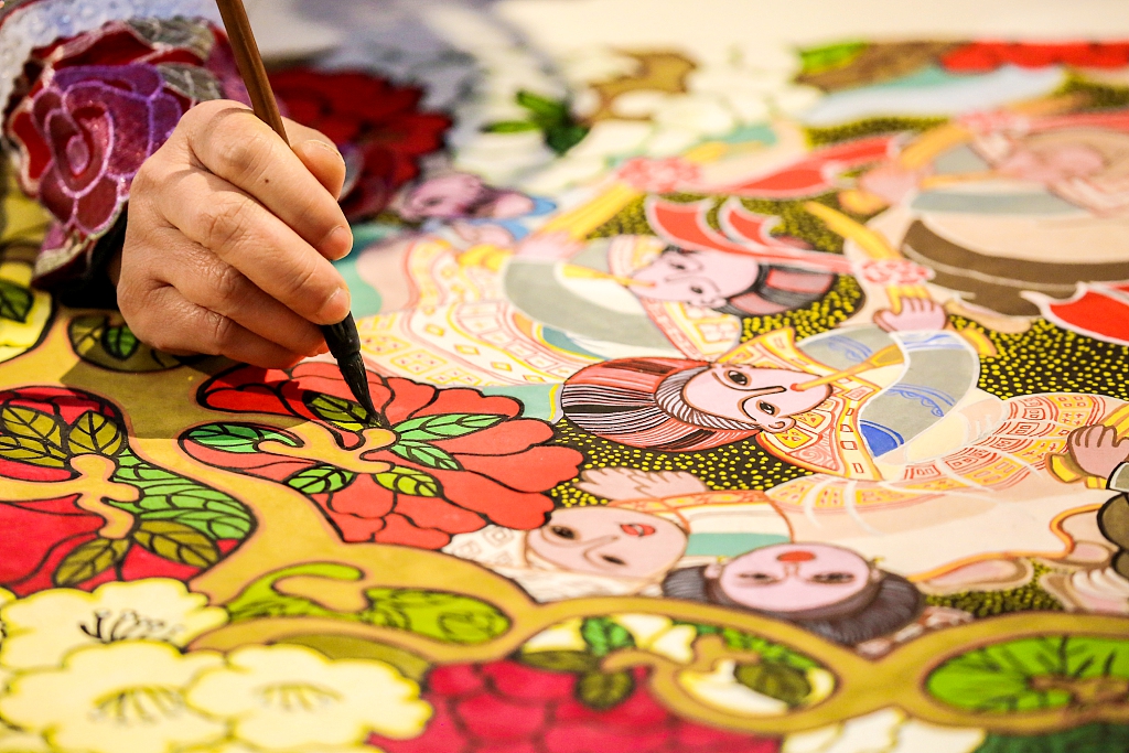 A folk artist creates a spring themed farmer painting in Bijie, Guizhou Province, March 7, 2024. /CFP