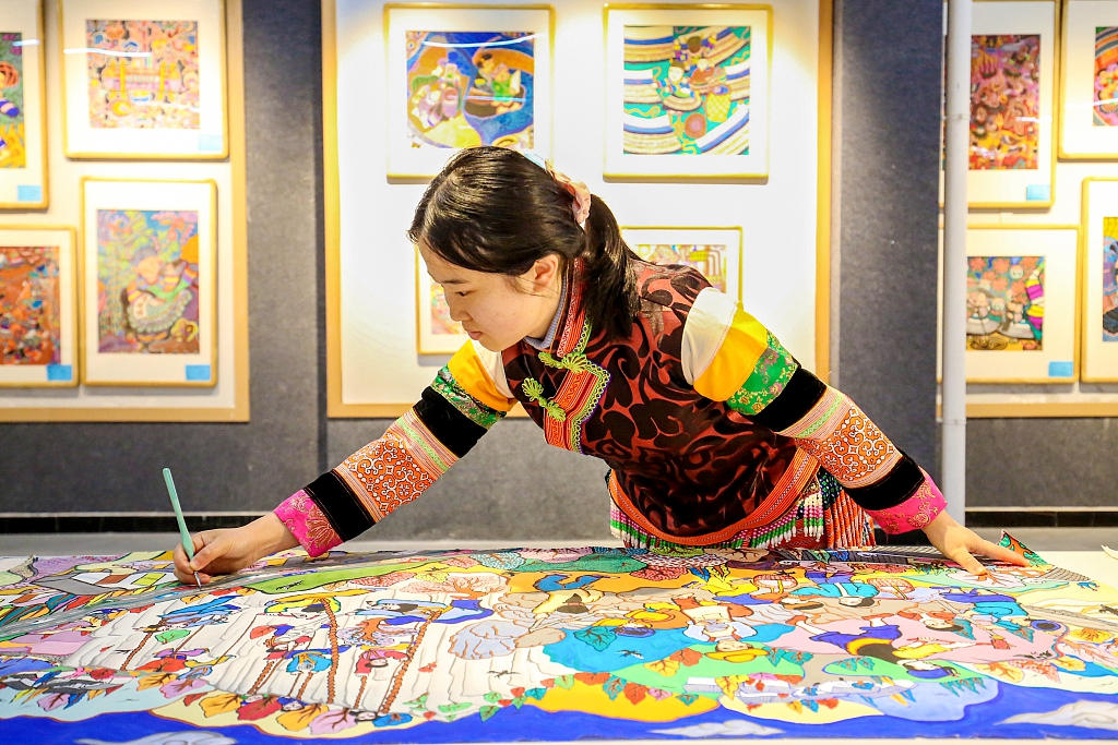 A folk artist creates a spring themed farmer painting in Bijie, Guizhou Province, March 7, 2024. /CFP