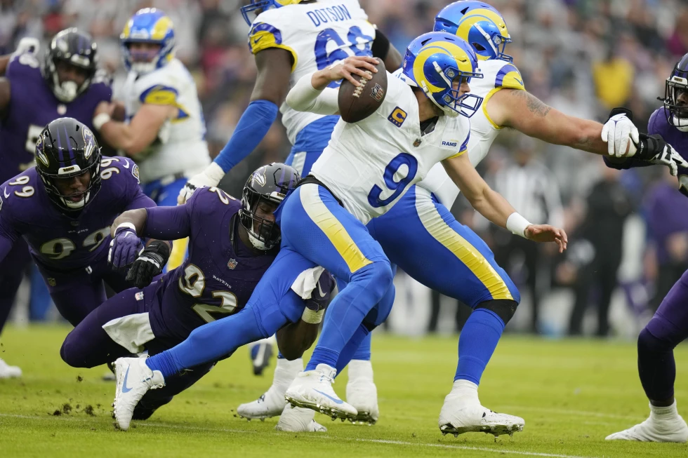 Quarterback Matthew Stafford (#9) of the Los Angeles Rams dodges a tackle by defensive tackle Justin Madubuike (#92) of the Baltimore Ravens in the game at M&T Bank Stadium in Baltimore, Maryland, December 10, 2023. /AP