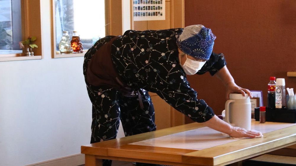 A woman cleans a desk at her shop in central Fukushima, Japan. /CGTN
