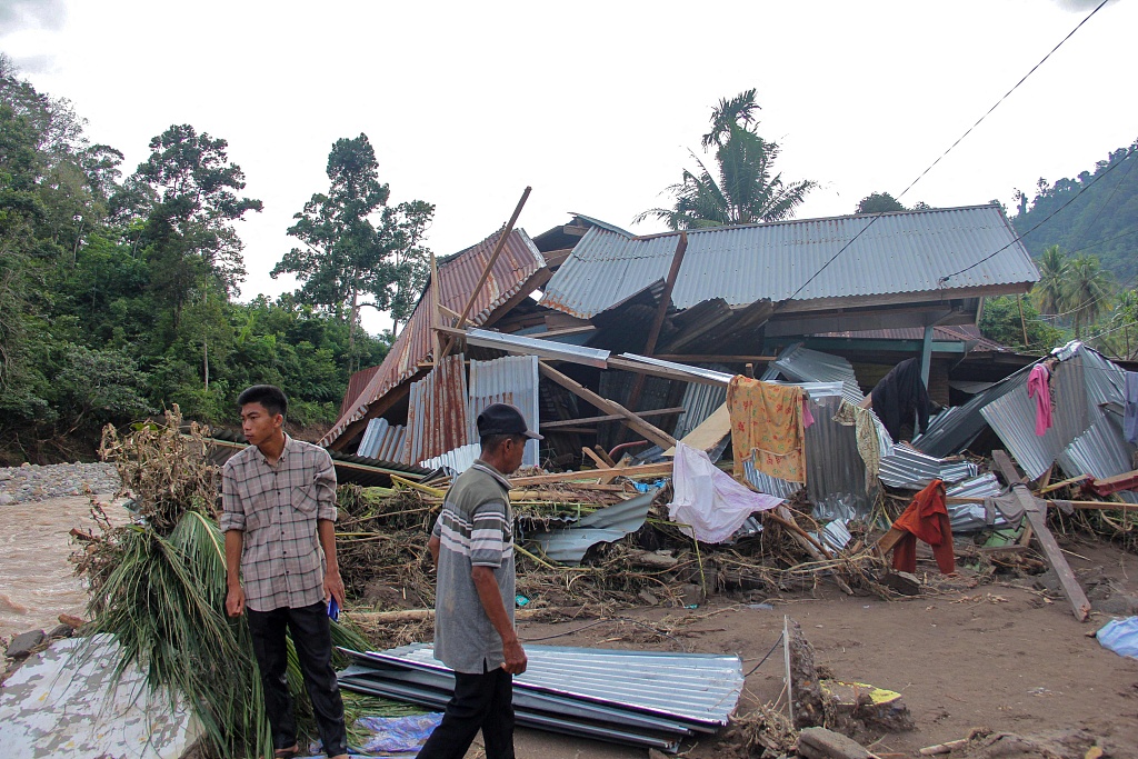 Villagers stand near a damaged house by a river after a flash flood at Pesisir Selatan in West Sumatra, Indonesia, March 10, 2024. /CFP