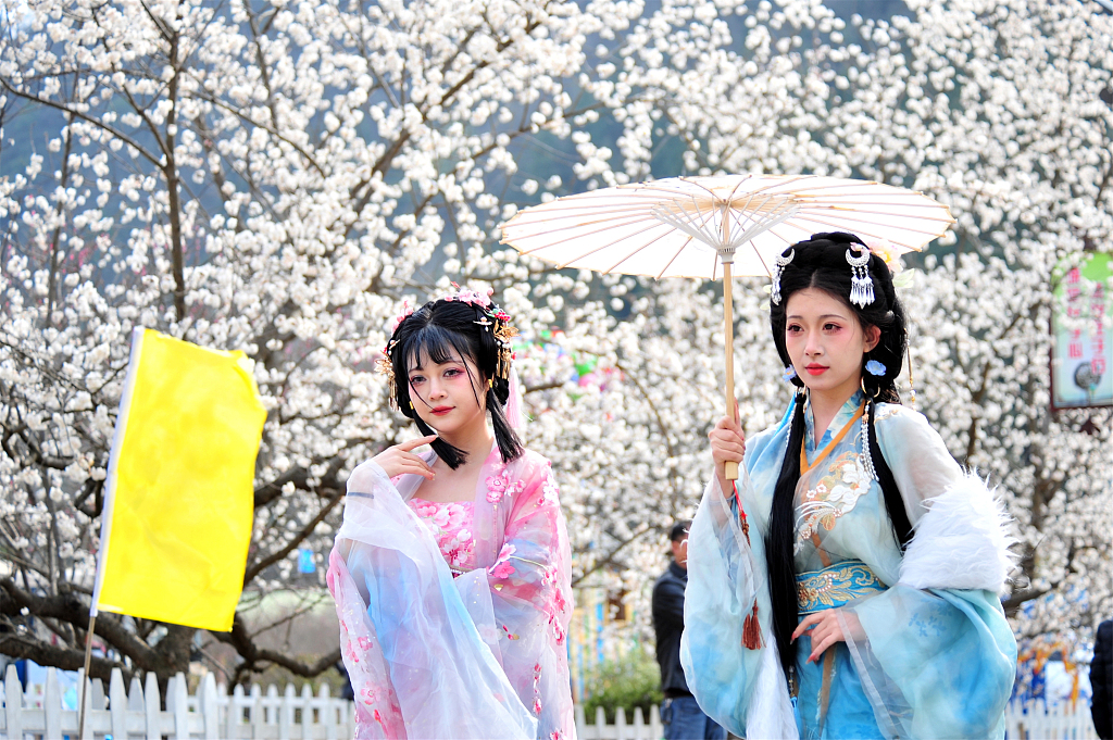 Dressed in hanfu, tourists pose for photos while visiting Shangyang Village in Yichang, Hubei Province on March 13, 2024. /CFP