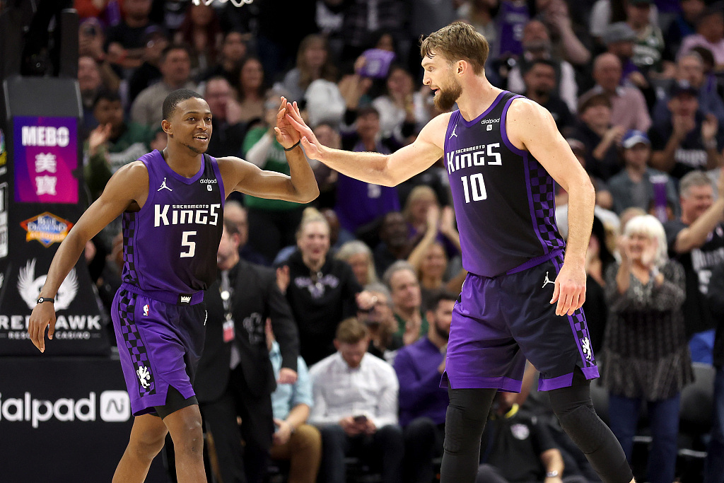 De'Aaron Fox (L) and Domantas Sabonis of the Sacramento Kings give each other high fives in the game against the Milwaukee Bucks at Golden 1 Center in Sacramento, California, March 12, 2024. /CFP