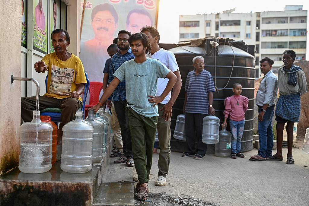 People stand in a queue with water cans to collect drinking water at subsidized rates amid an ongoing water crisis, at a water dispensing center in Bengaluru, India, March 11, 2024. /CFP