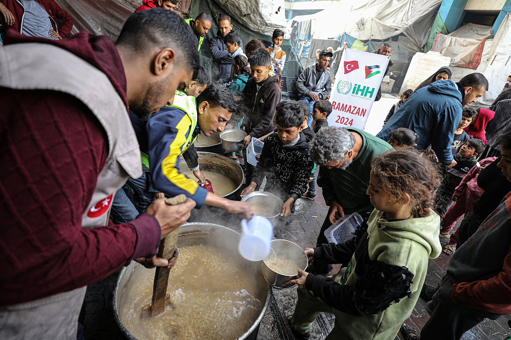 Humanitarian Relief Foundation workers distribute food on the 4th day of Ramadan to Palestinians who fled the attacks and took refuge to schools in Gaza City, Gaza, March 14, 2024. /CFP