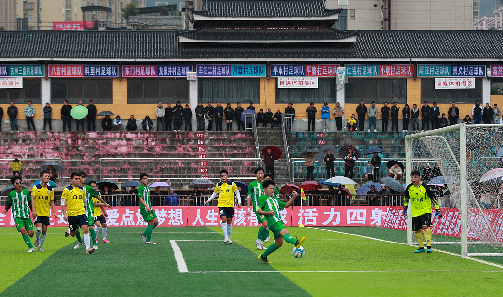A footballer attempts to shoot during the preliminary round match of the Village Super League in Rongjiang, China, January 6, 2024. /CFP