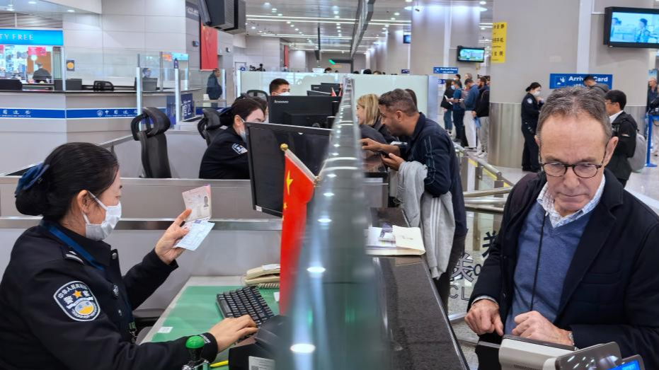 Border police officers check documents of travelers at a border checkpoint of the Shanghai Pudong International Airport in east China's Shanghai, March 14, 2024. /Xinhua