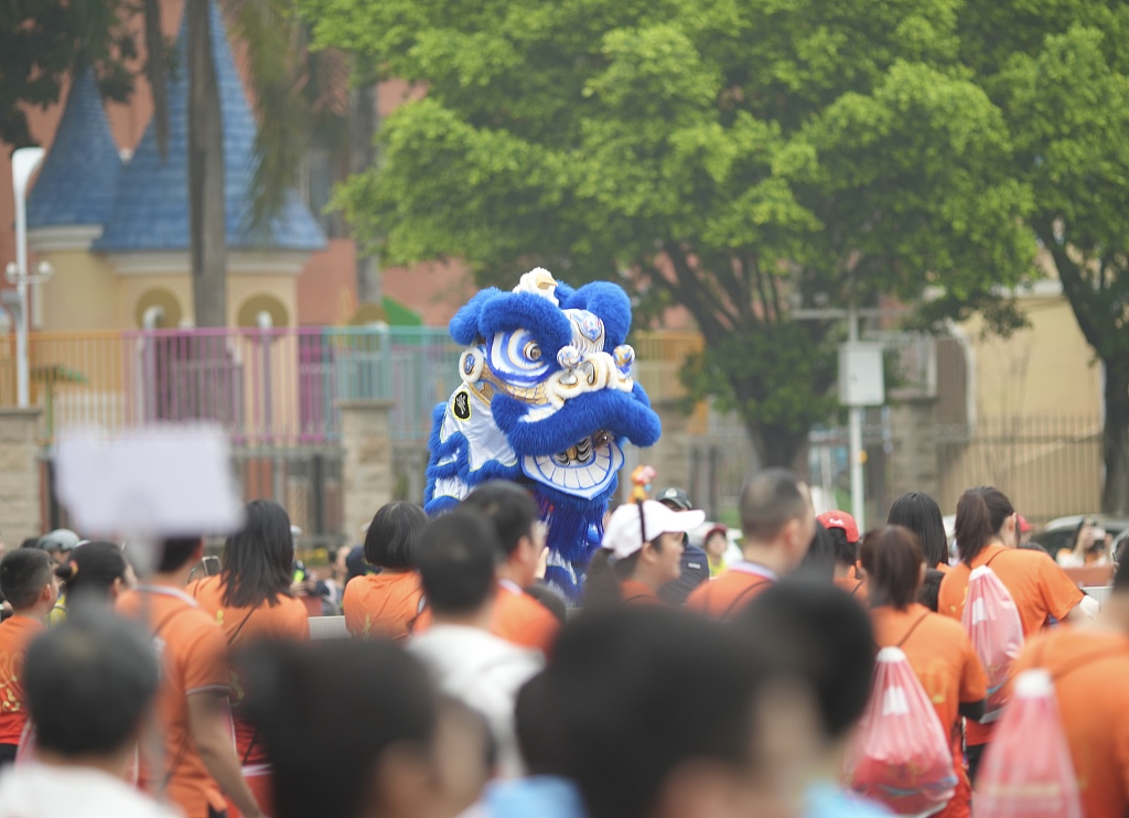 A lion dance performance is shown during a marathon in Qingyuan, south China's Guangdong Province, March 17, 2024. /CFP 