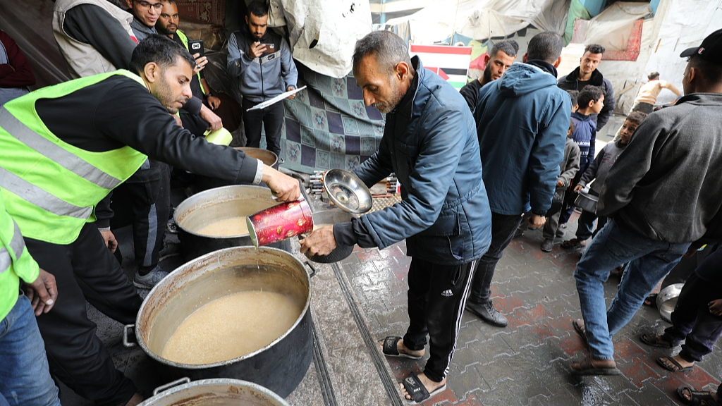 Workers from a Turkish NGO distribute food to Palestinians in Gaza, March 14, 2024. /CFP