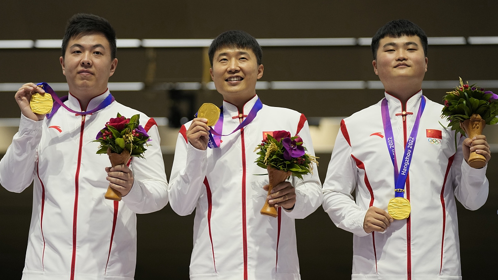 China's Li Yuehong (C) during the awards ceremony for team men's 25-meter rapid fire pistol shooting at the 19th Asian Games in Hangzhou, China, September 25, 2023. /CFP
