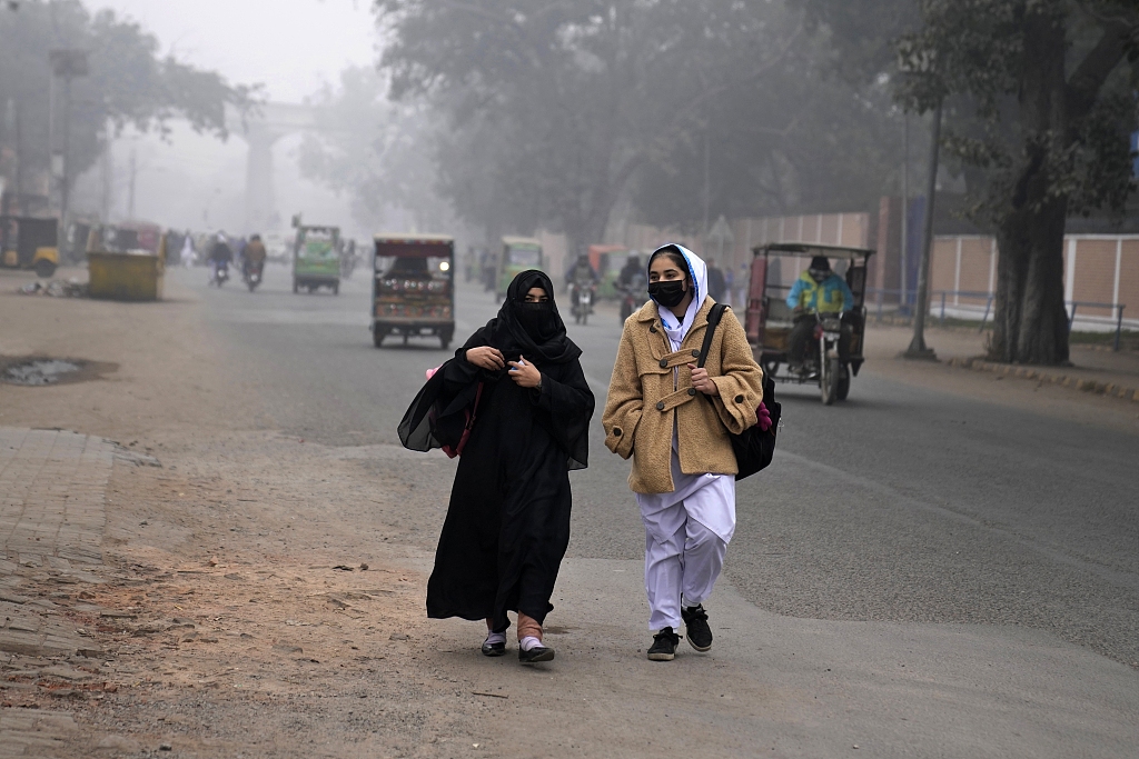 Students walk to school wearing masks as smoke envelops Lahore, Pakistan,January 15, 2024. /CFP