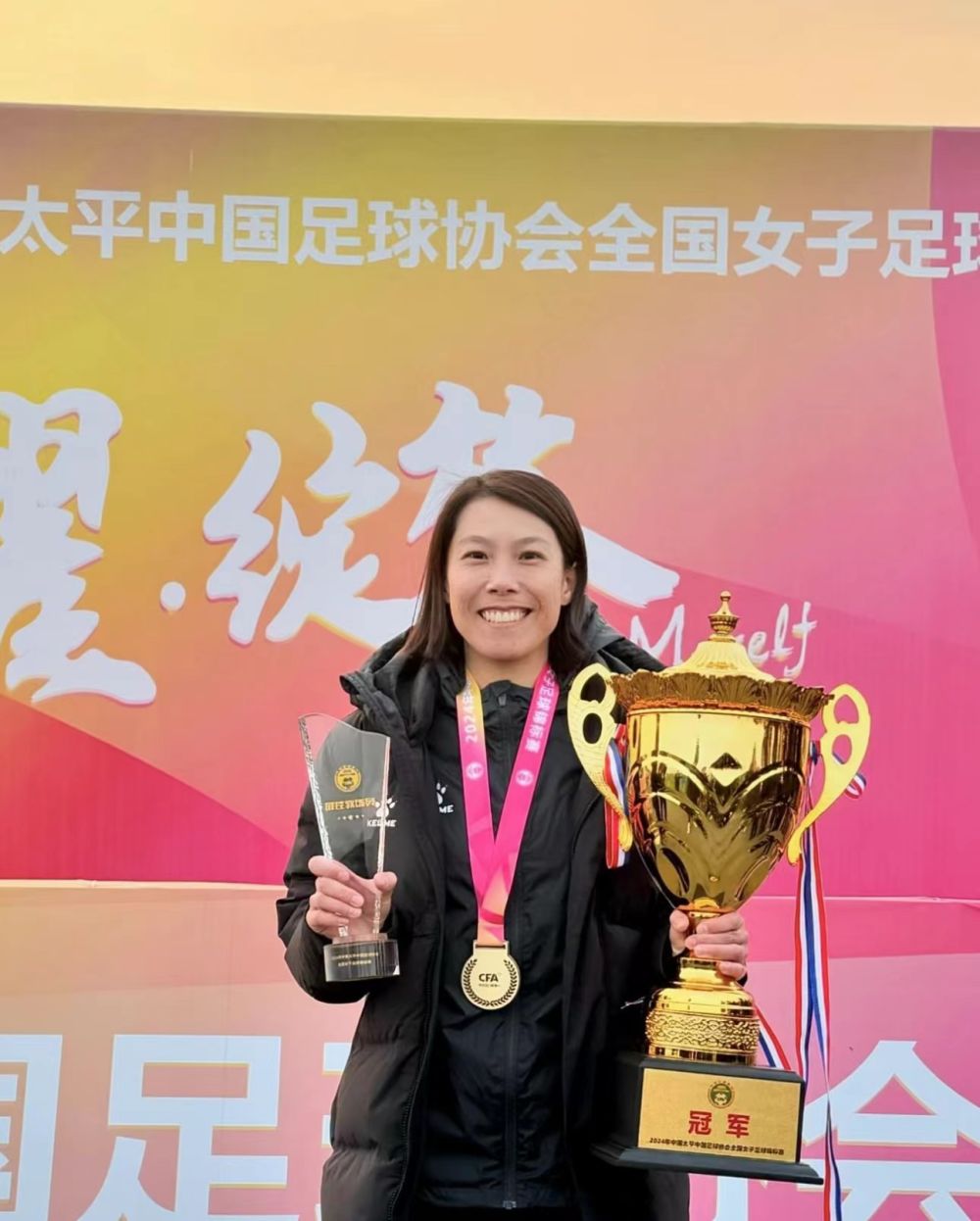 Chen Wanting, manager of Jiangsu, poses with the trophy after winning the Chinese National Women's Football Championship, March 8, 2024. /Xinhua